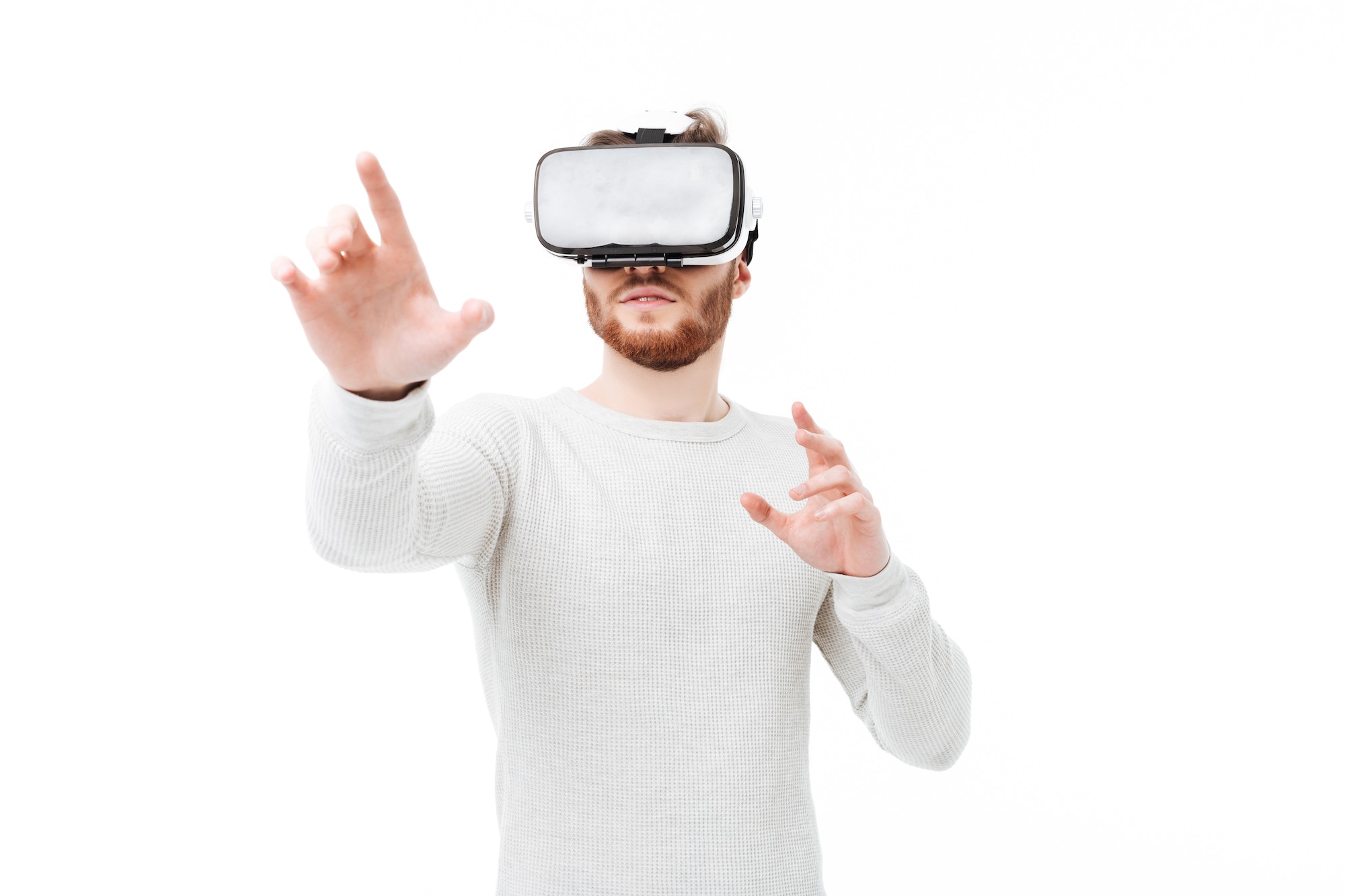 Portrait of young man in studio using virtual reality glasses over white background